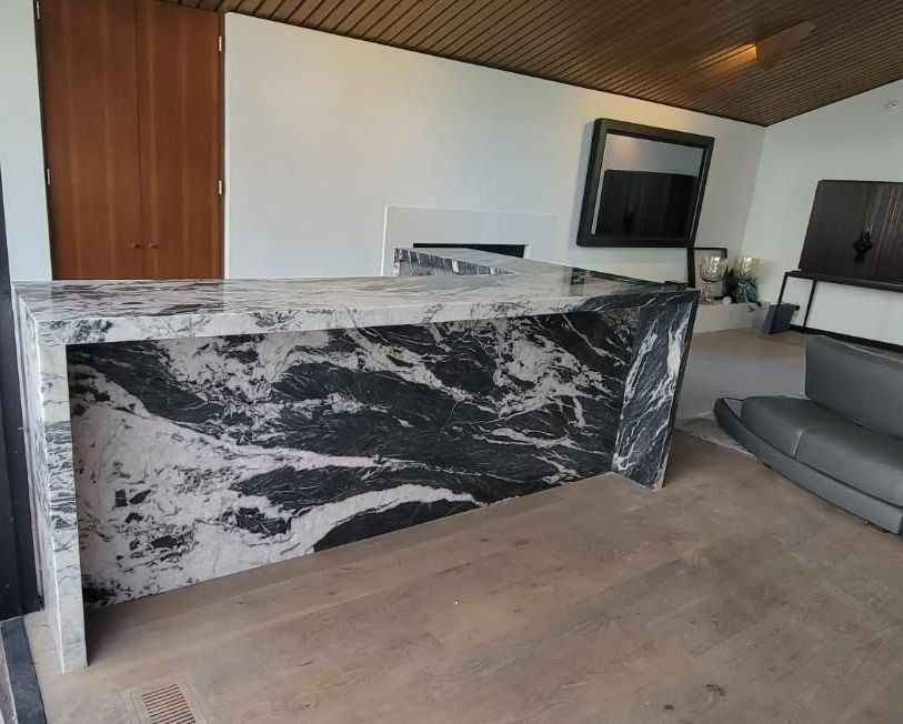A black and white marble counter in a living room with a couch.