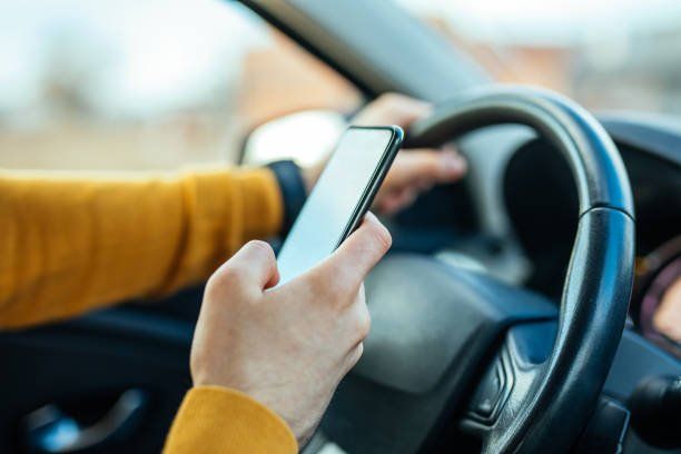 Male Using Mobile Phone While Driving The Car — Indianapolis, IN — Wegner C Dennis & Assoc