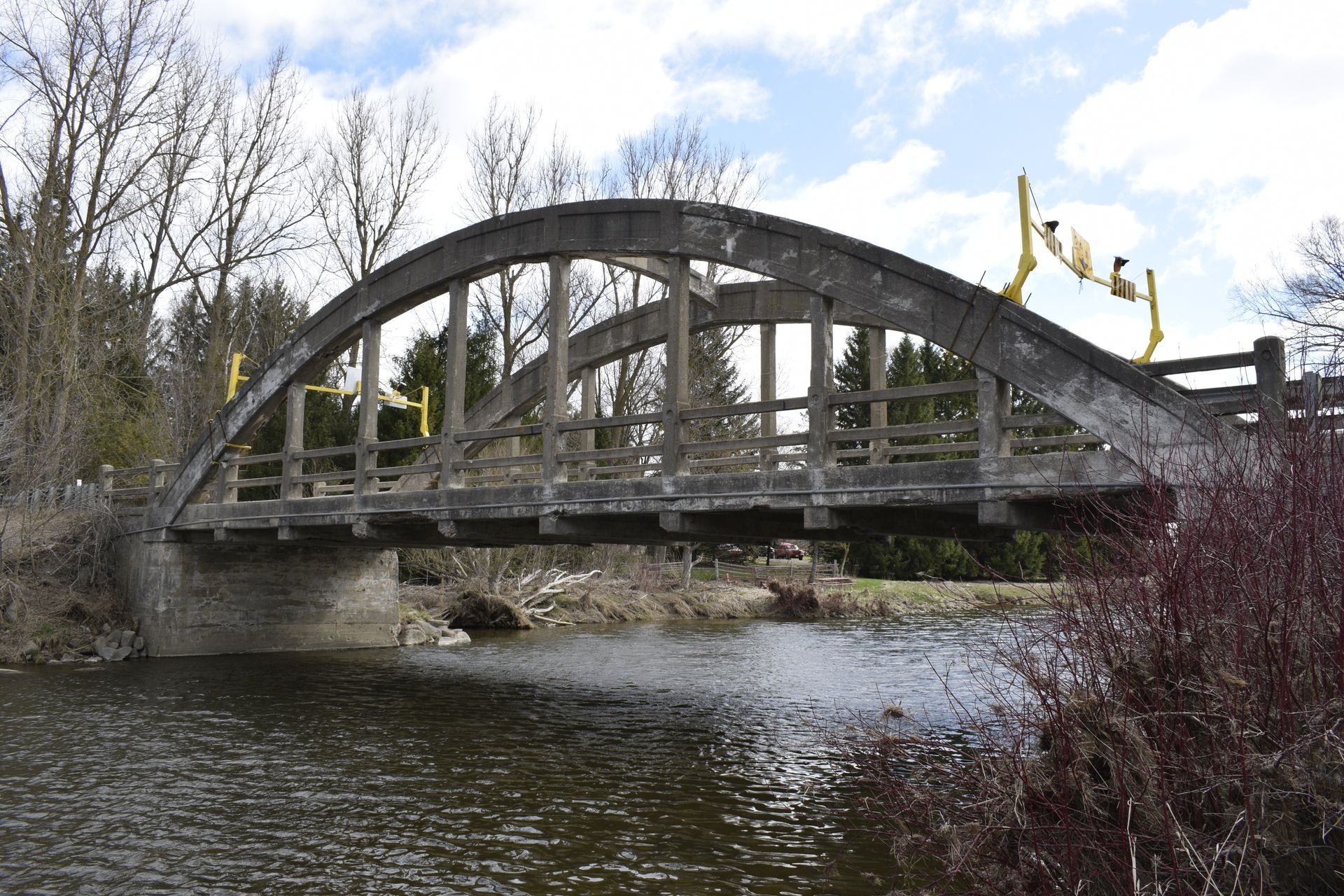 Old concrete bowstring through arch bridge over a river