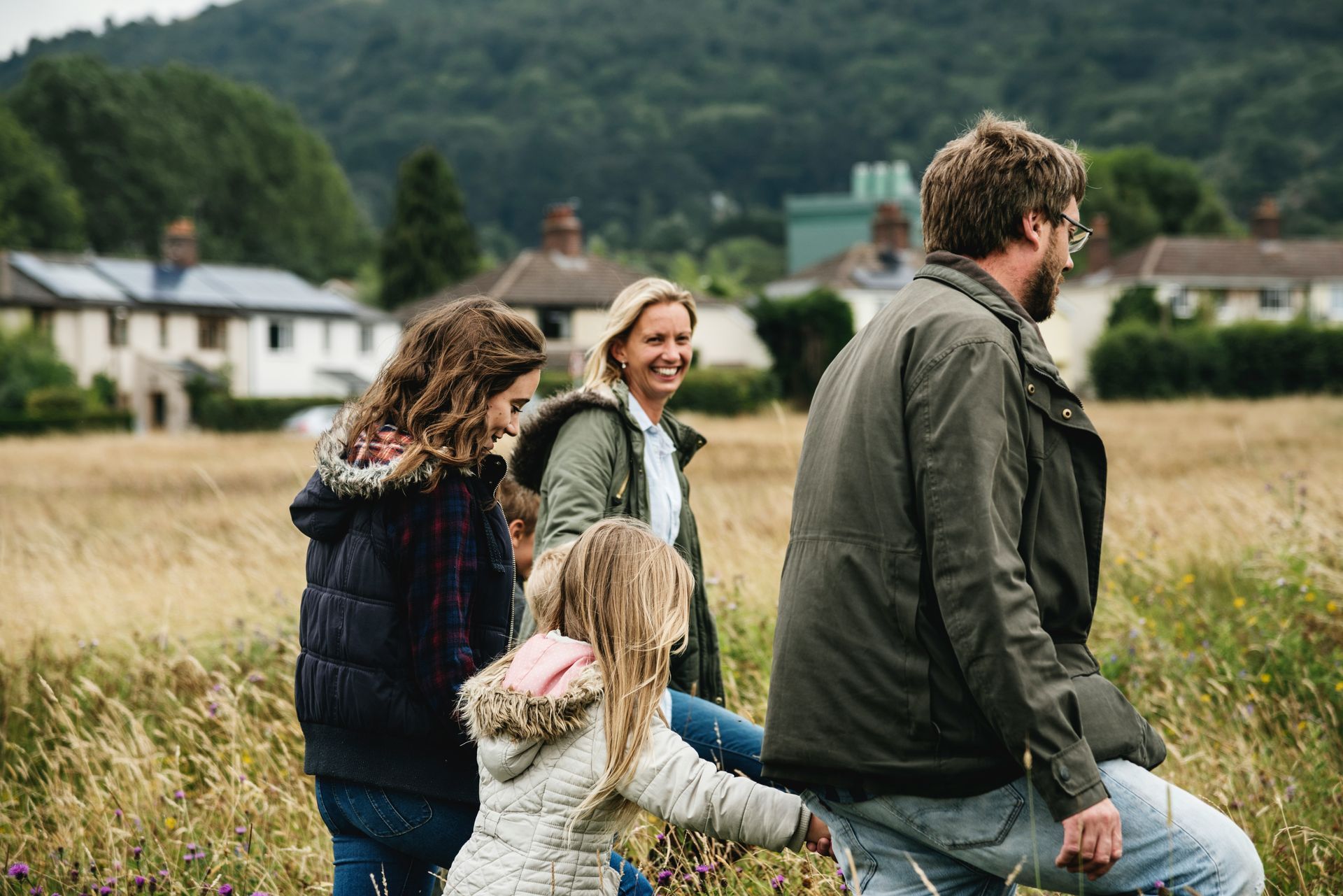 Man shows older man tablet while cooking in kitchen.