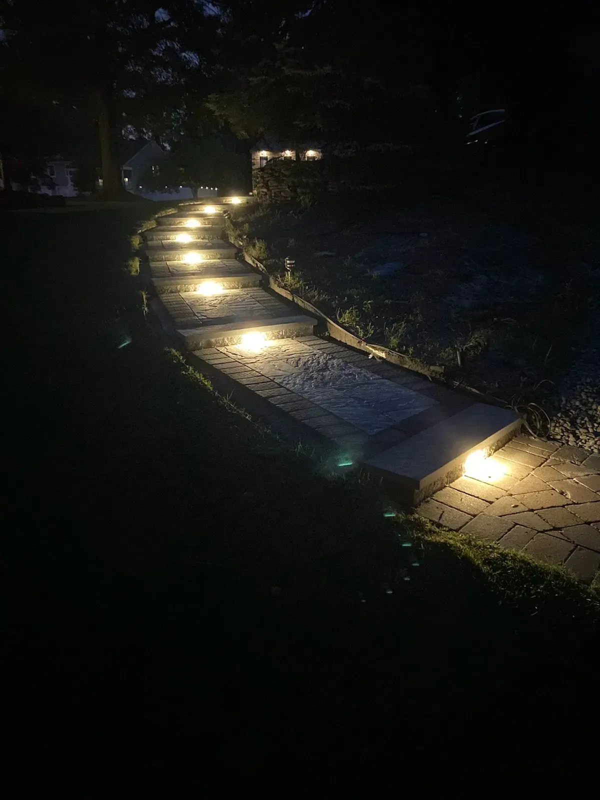 A walkway with lights on it is lit up at night.