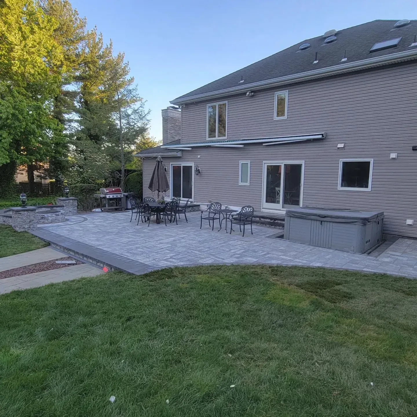 A large house with a patio and a hot tub in front of it.