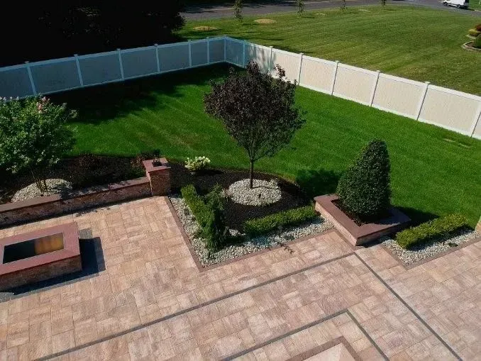 An aerial view of a backyard with a fire pit and a fence.