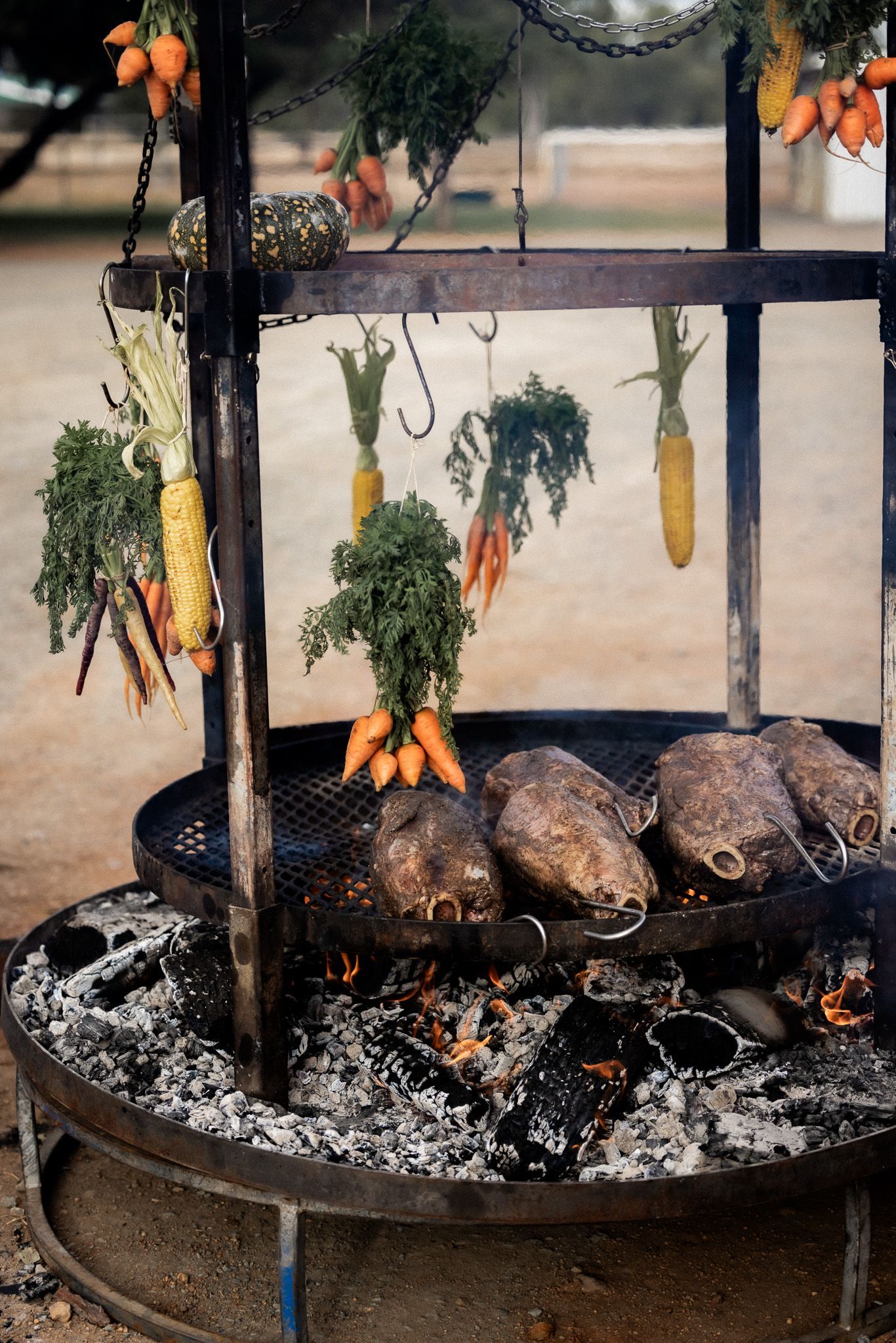 Carrots and corn are being cooked on a grill