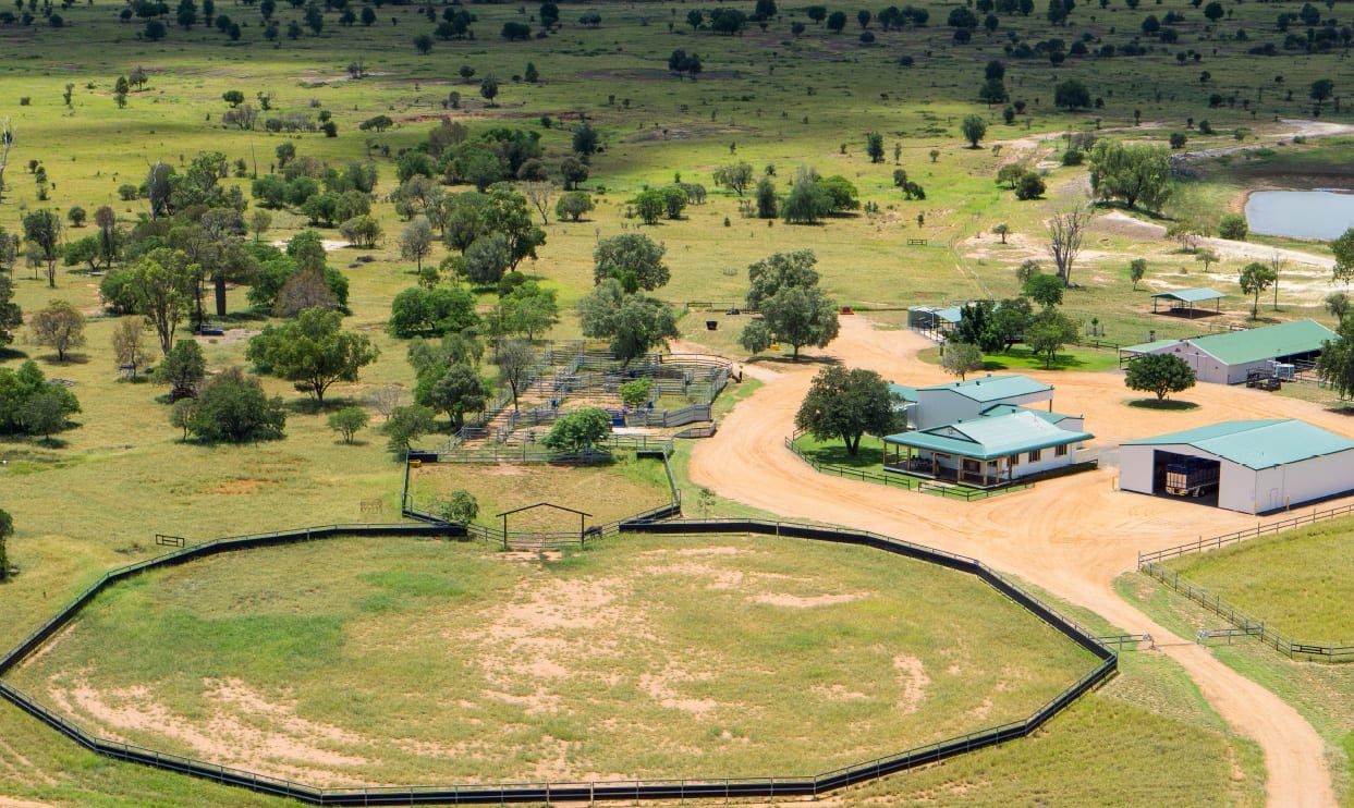 An aerial view of a farm with a fence around it