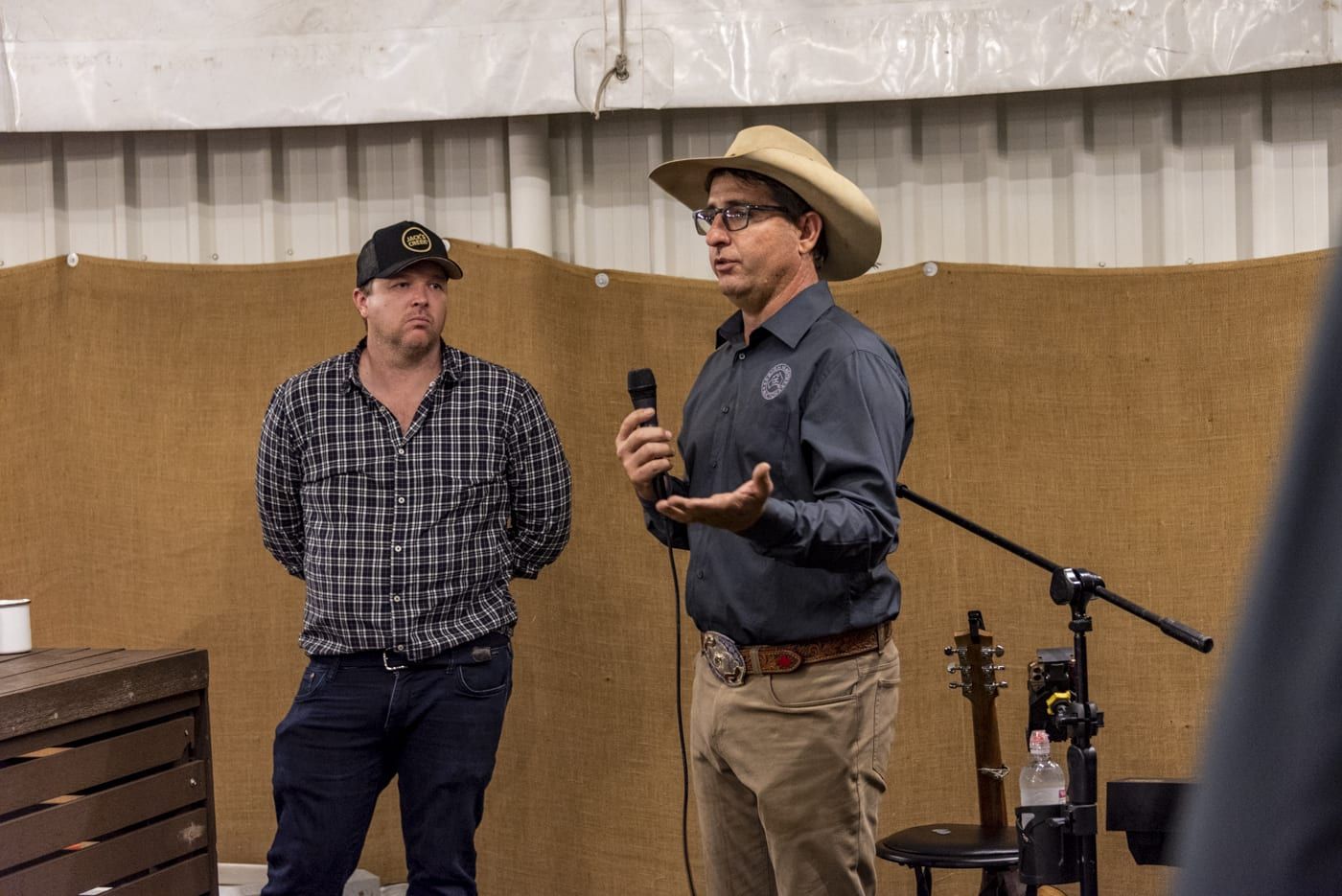 Two men speaking at an event. 