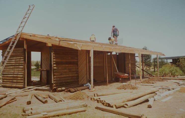 A group of people are working on a wooden house