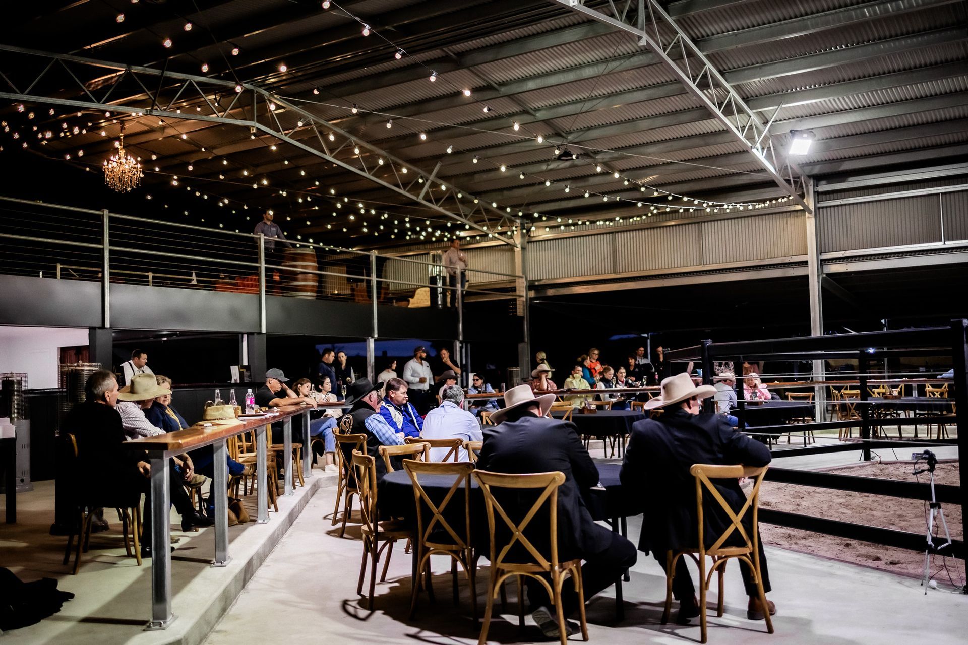 A group of people are sitting at tables in a large room.