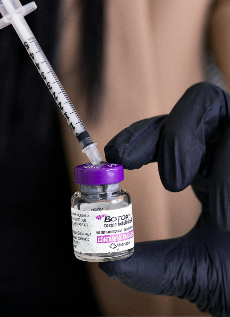 A woman is getting a botox injection in her face.