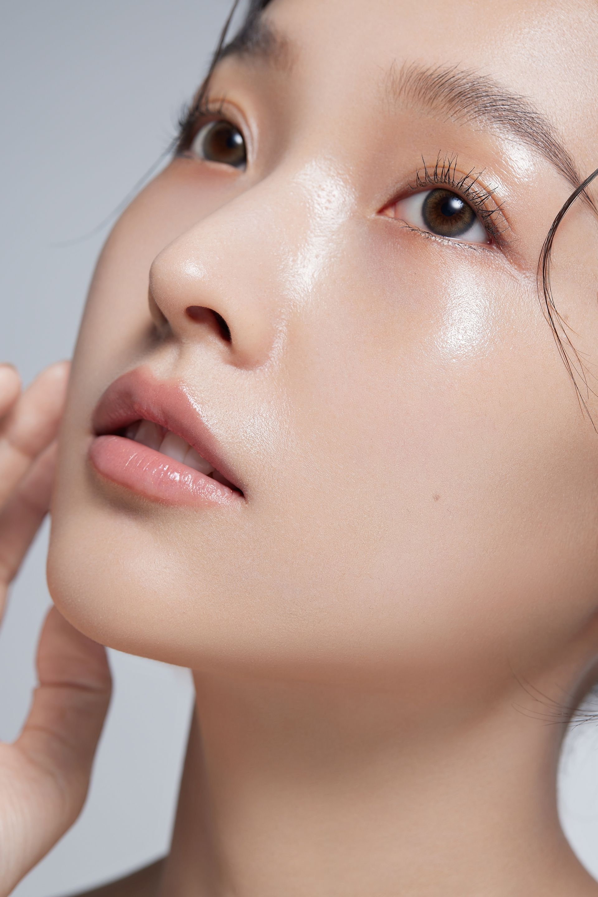 A close up of a woman 's face with a hand on her chin.
