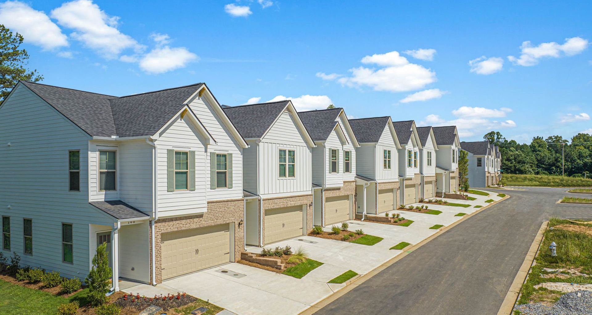 A row of white houses sitting next to each other on a sunny day at Mayridge Canton FKA Summerwalk Townhomes