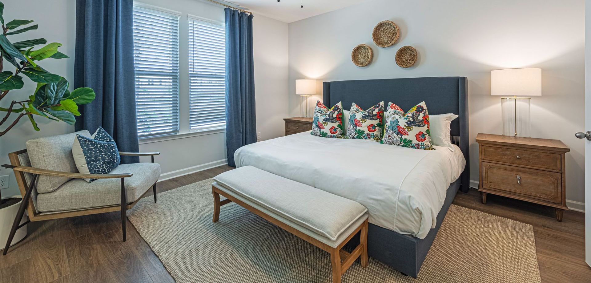 A bedroom with a king size bed , chair , nightstand and bench at Mayridge Canton FKA Summerwalk Townhomes