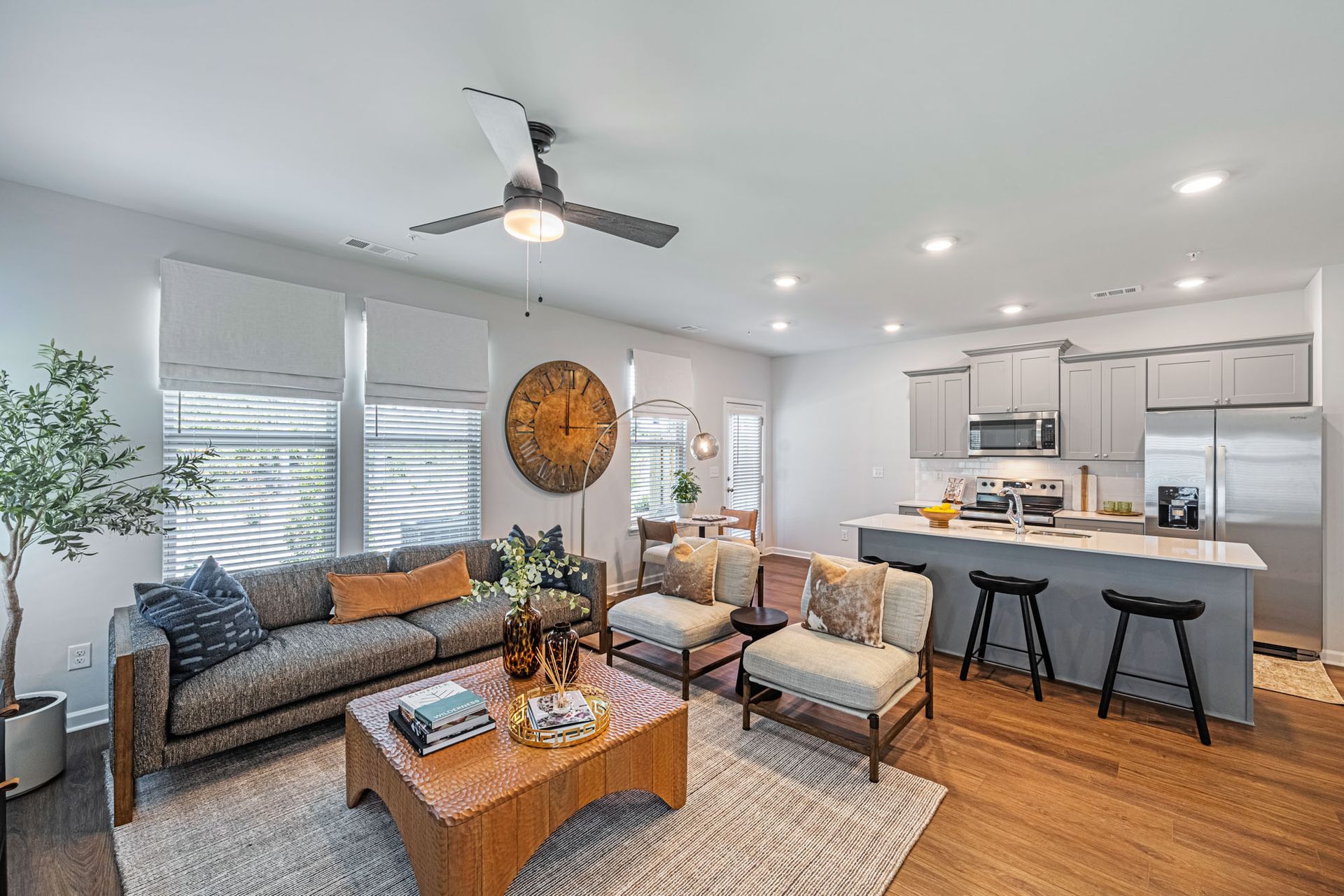 A living room with a couch , chairs , a coffee table and a ceiling fan at Mayridge Canton FKA Summerwalk Townhomes
