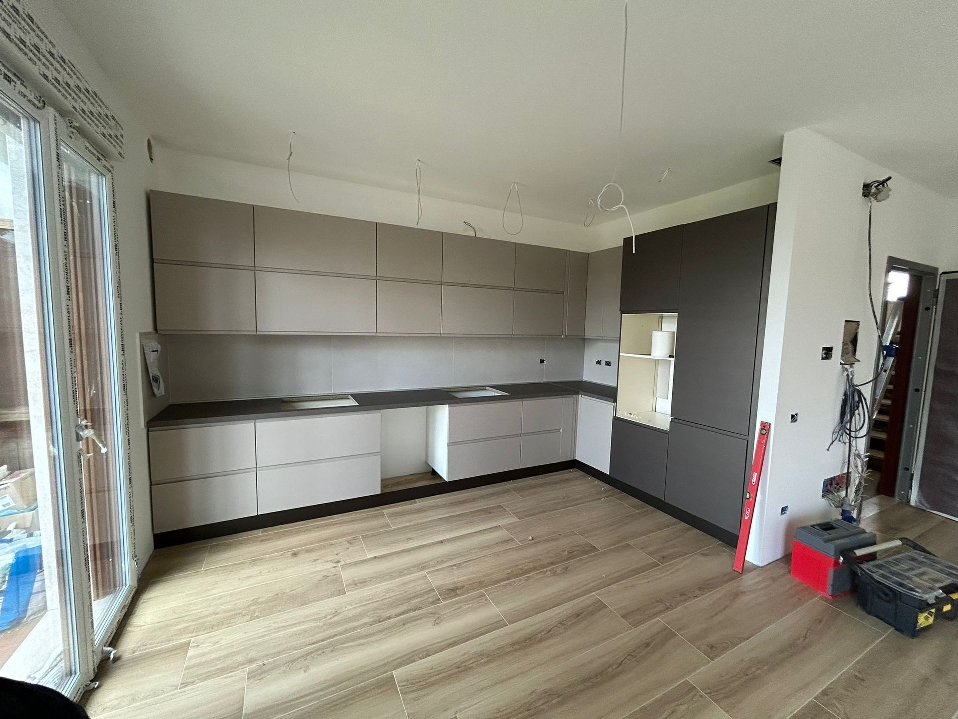 Una cucina con molti mobili e un pavimento in legno