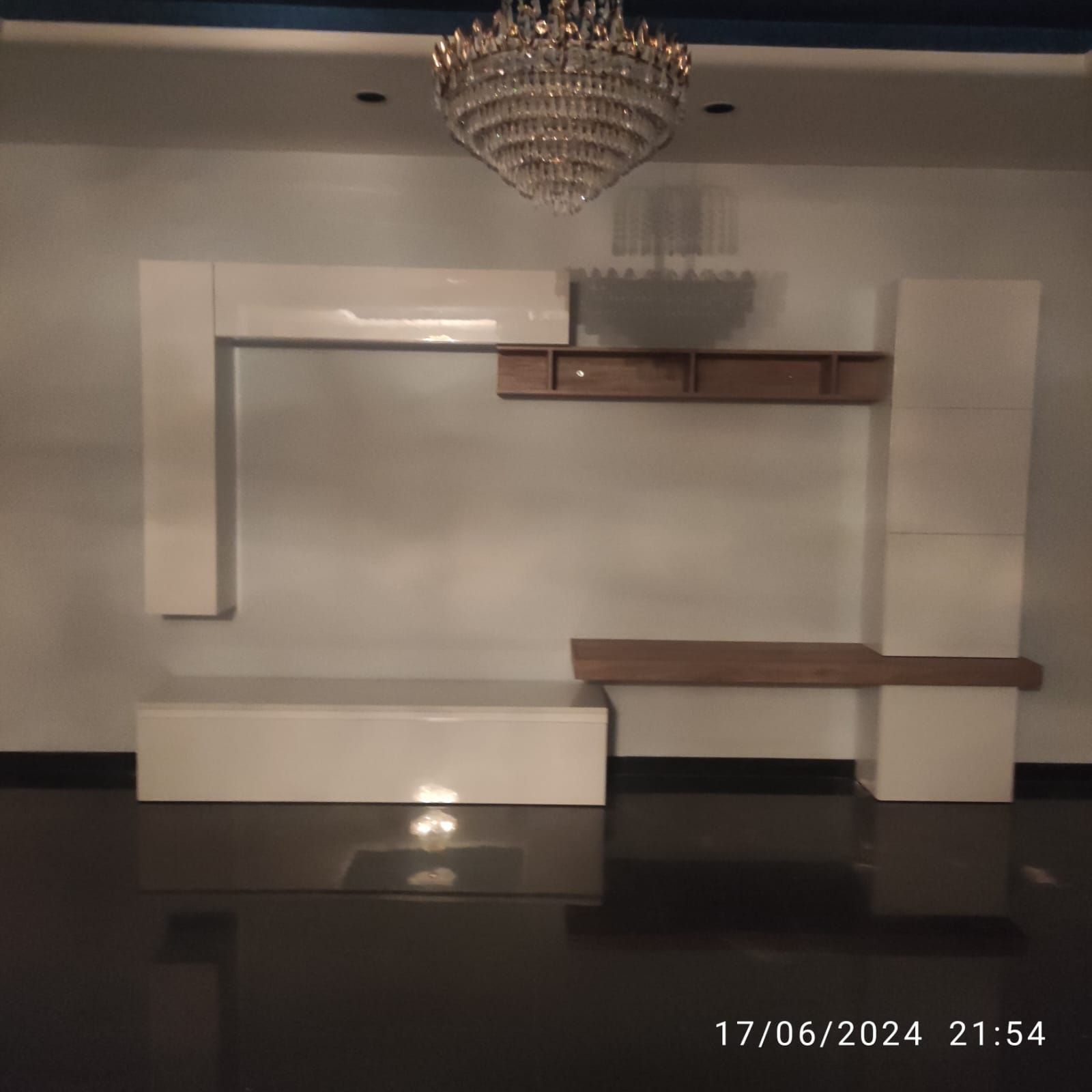 Una stanza vuota con un lampadario appeso al soffitto