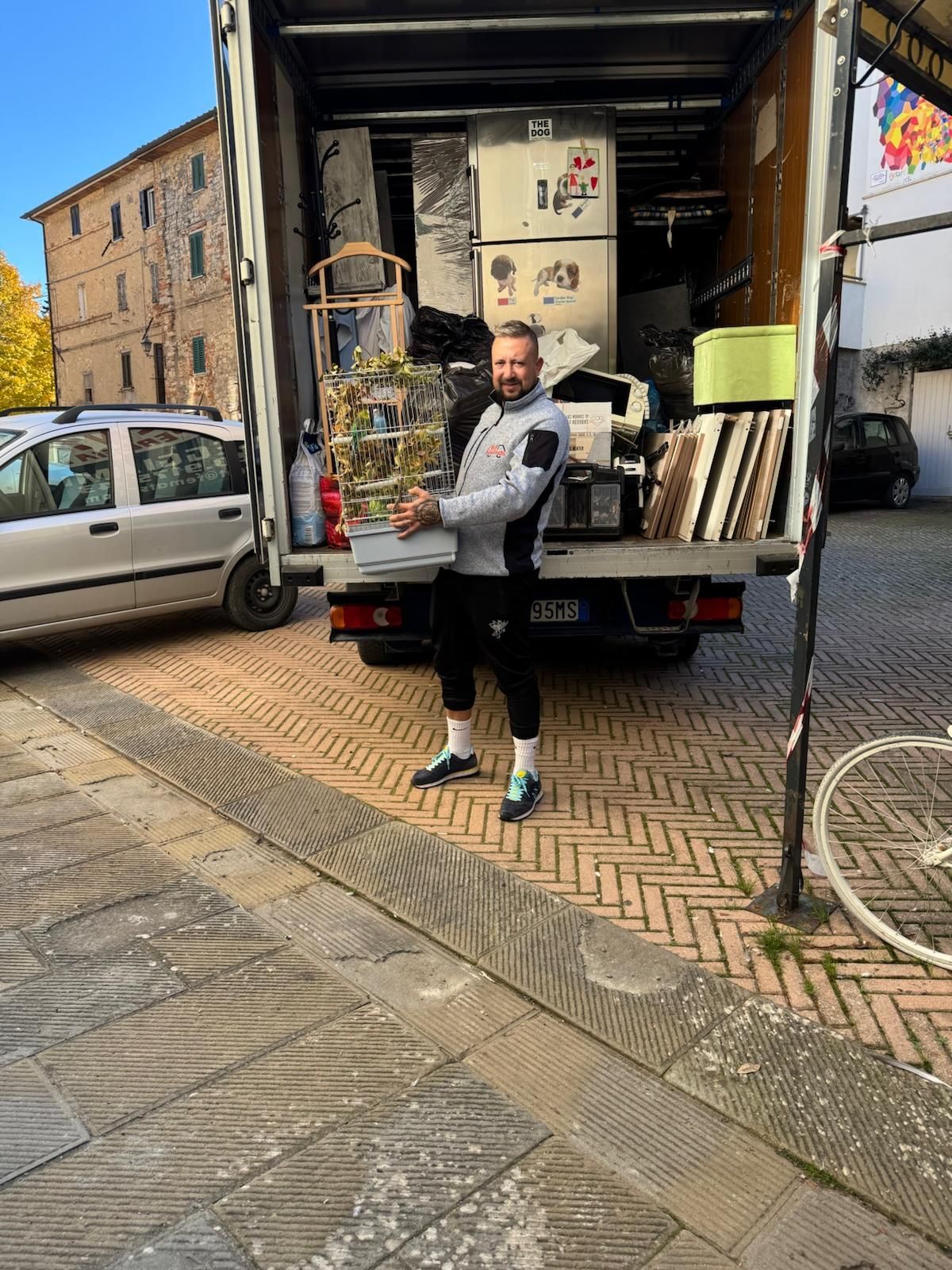Un uomo è in piedi davanti a un camion pieno di mobili.
