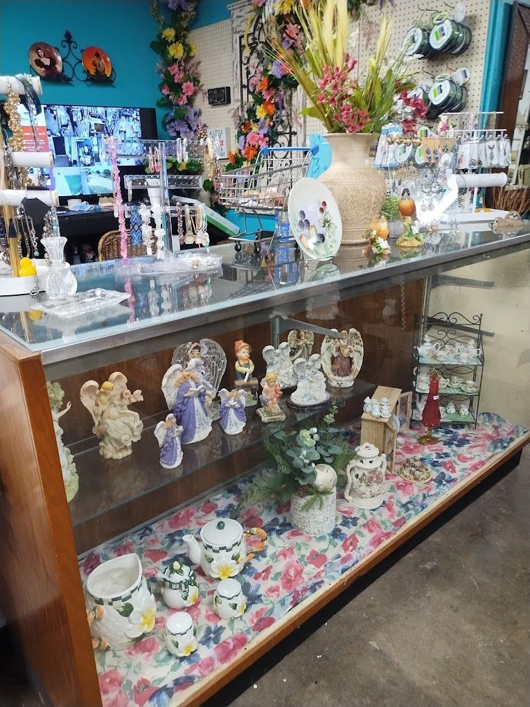 A glass display case filled with figurines and flowers in a store.