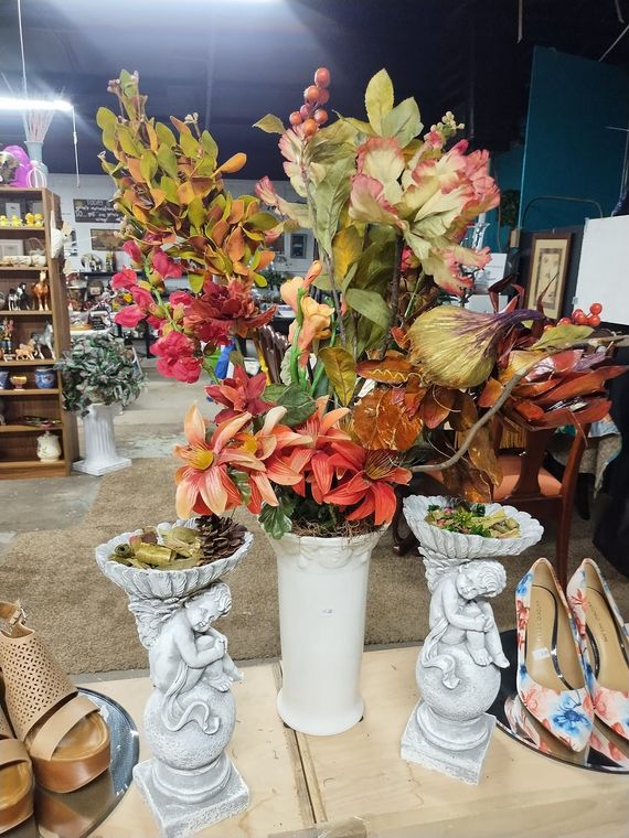 Three vases filled with flowers are sitting on a table in a store.