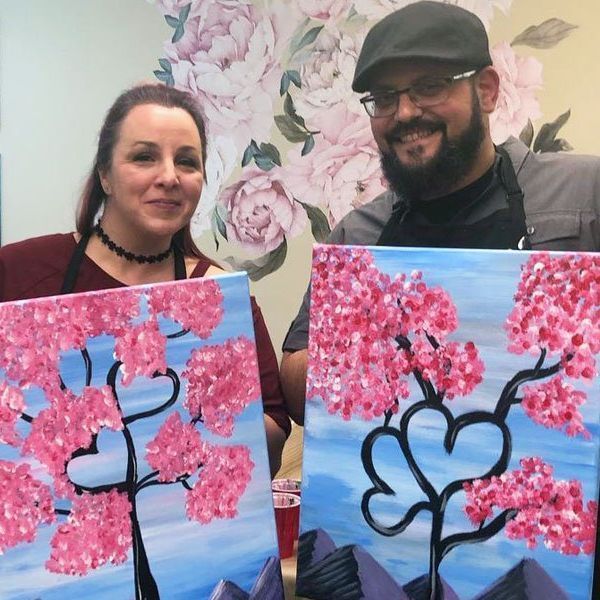 Couple painting a heart shape design.