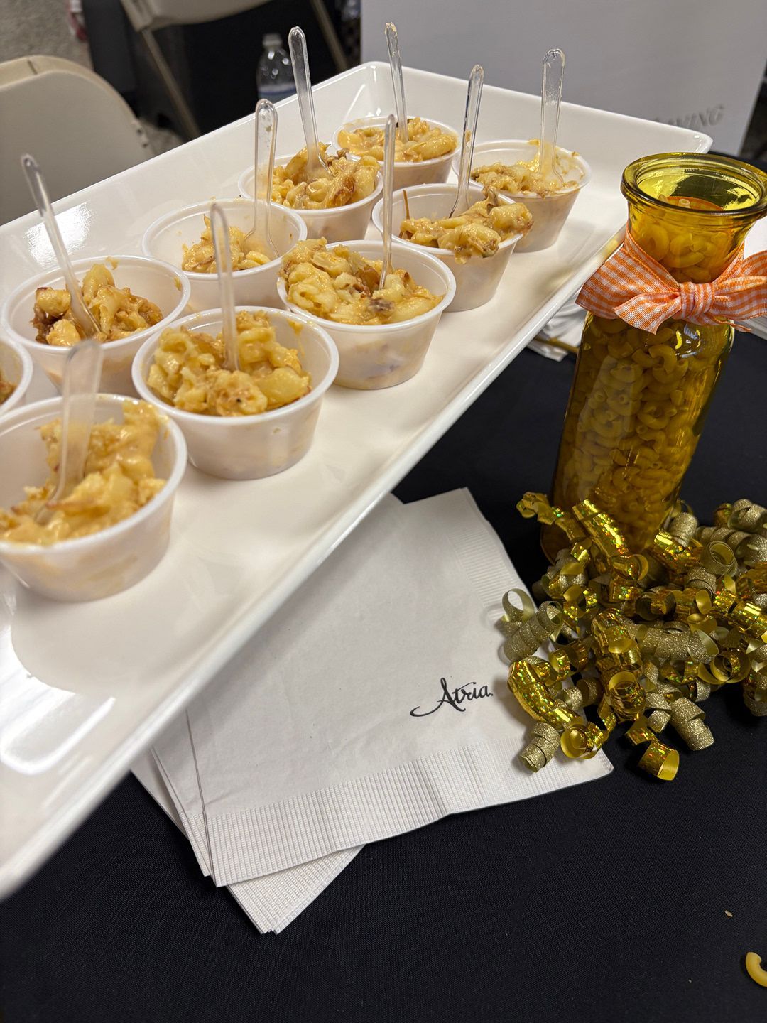 Two men are standing next to each other eating food at a festival.