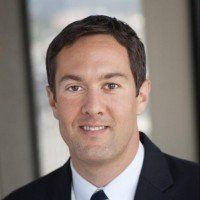 A man in a suit and tie is smiling for the camera.