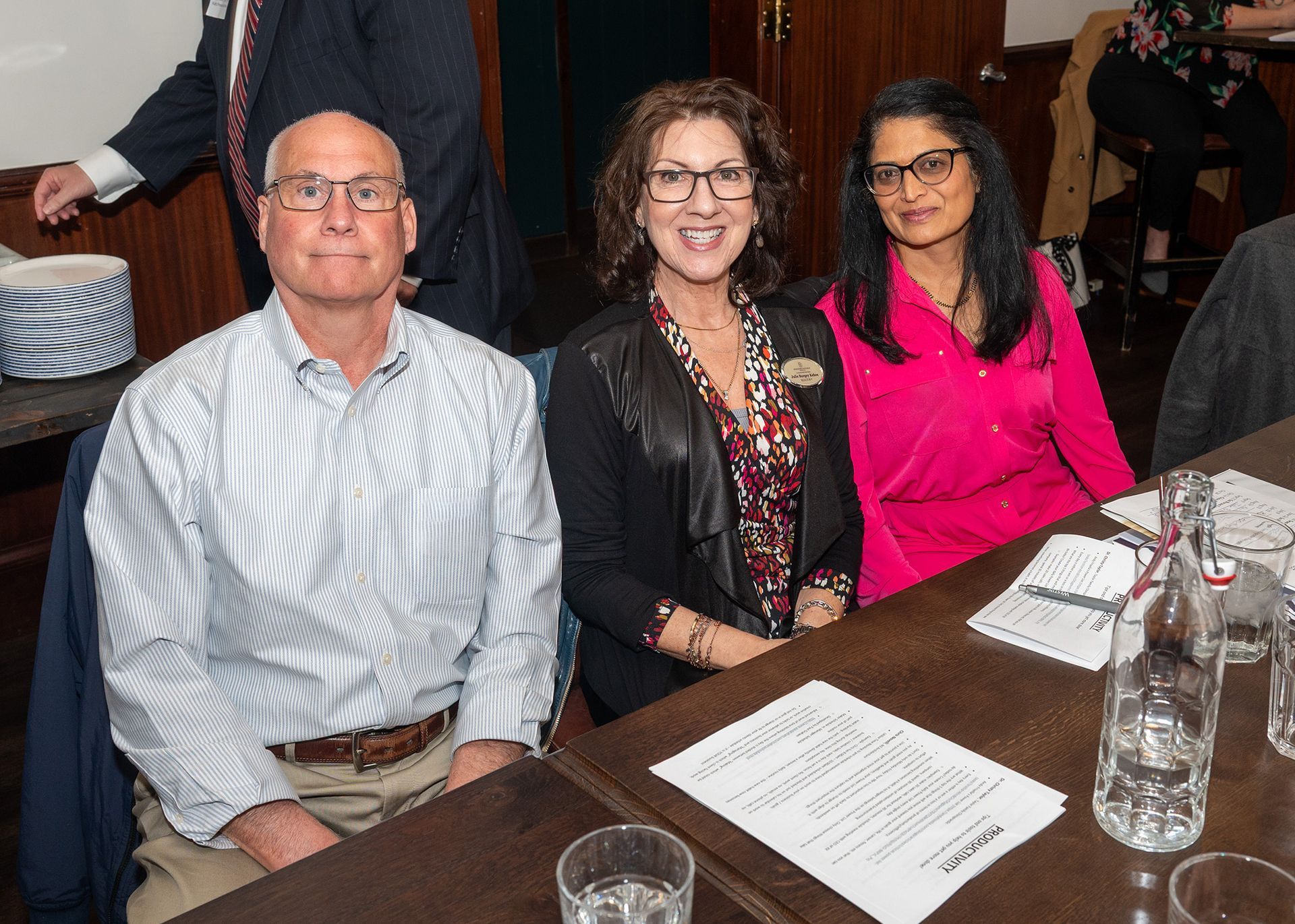 A man and two women are sitting at a table.