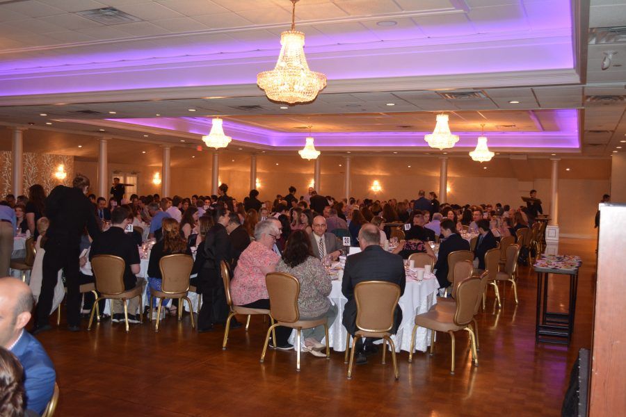 A large room filled with people sitting at tables and chairs.