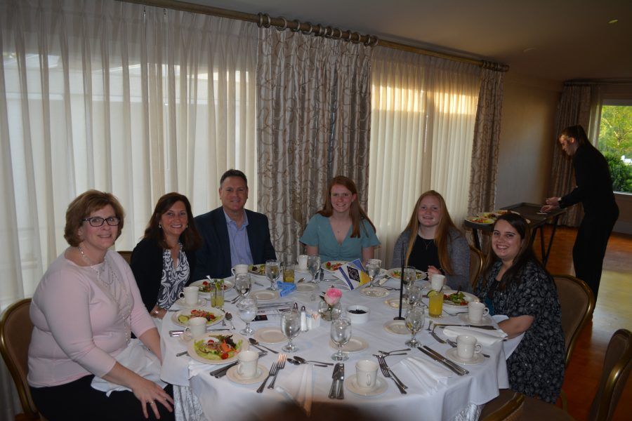 A group of people are sitting at a table with food.