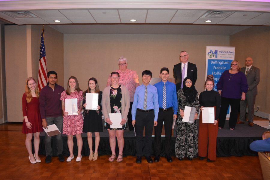 A group of people standing next to each other on a stage holding certificates.