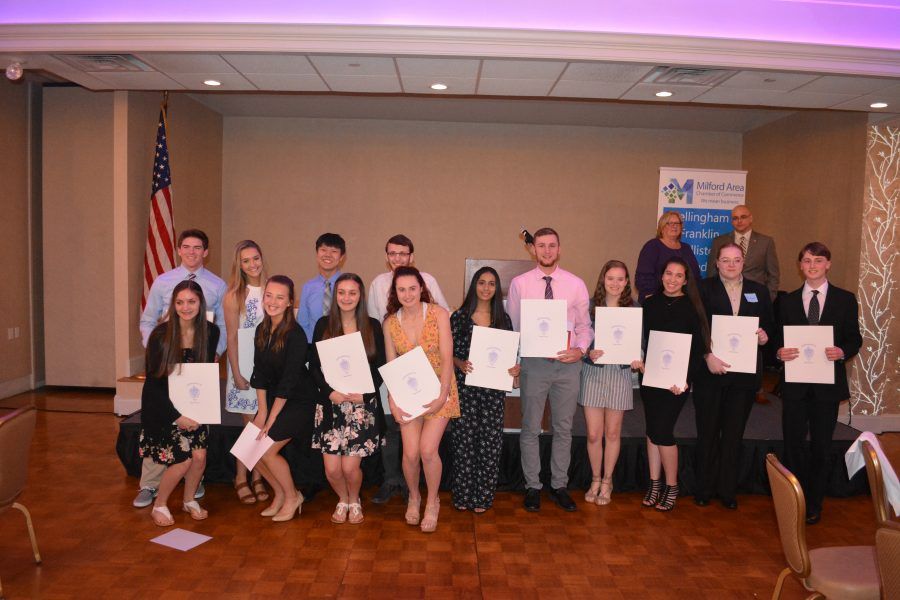 A group of people are posing for a picture in a room holding certificates.