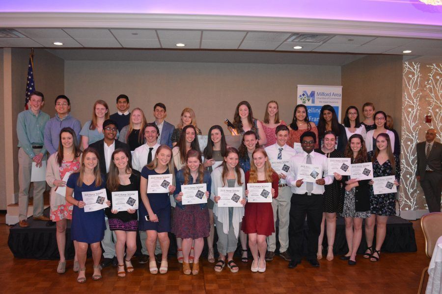 A group of people are posing for a picture in a room holding certificates.