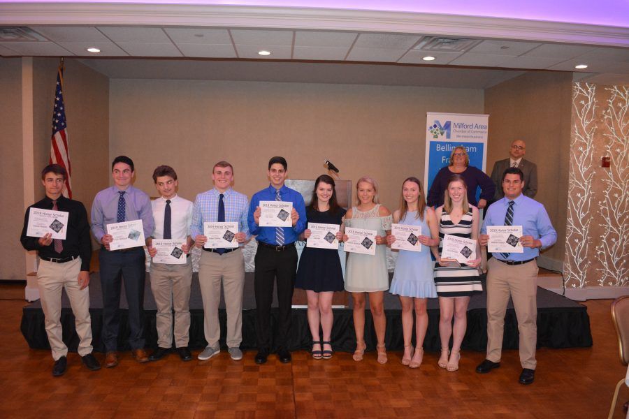 A group of people are standing in a room holding certificates.