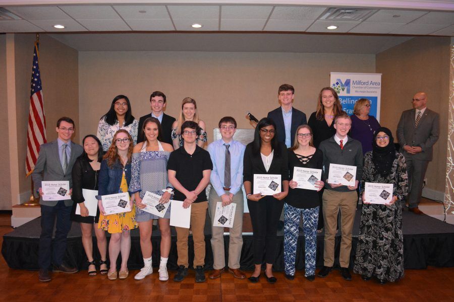 A group of people standing on a stage holding certificates.