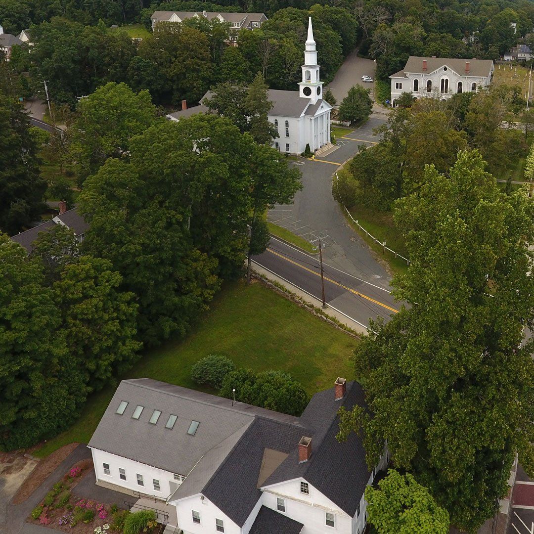 An aerial view of a church surrounded by trees and houses