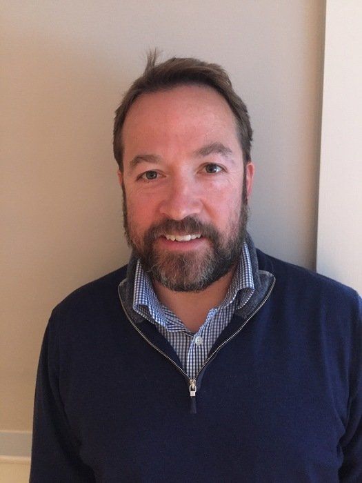 A man with a beard is wearing a blue sweater