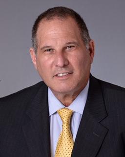 A man in a suit and tie is smiling for the camera.