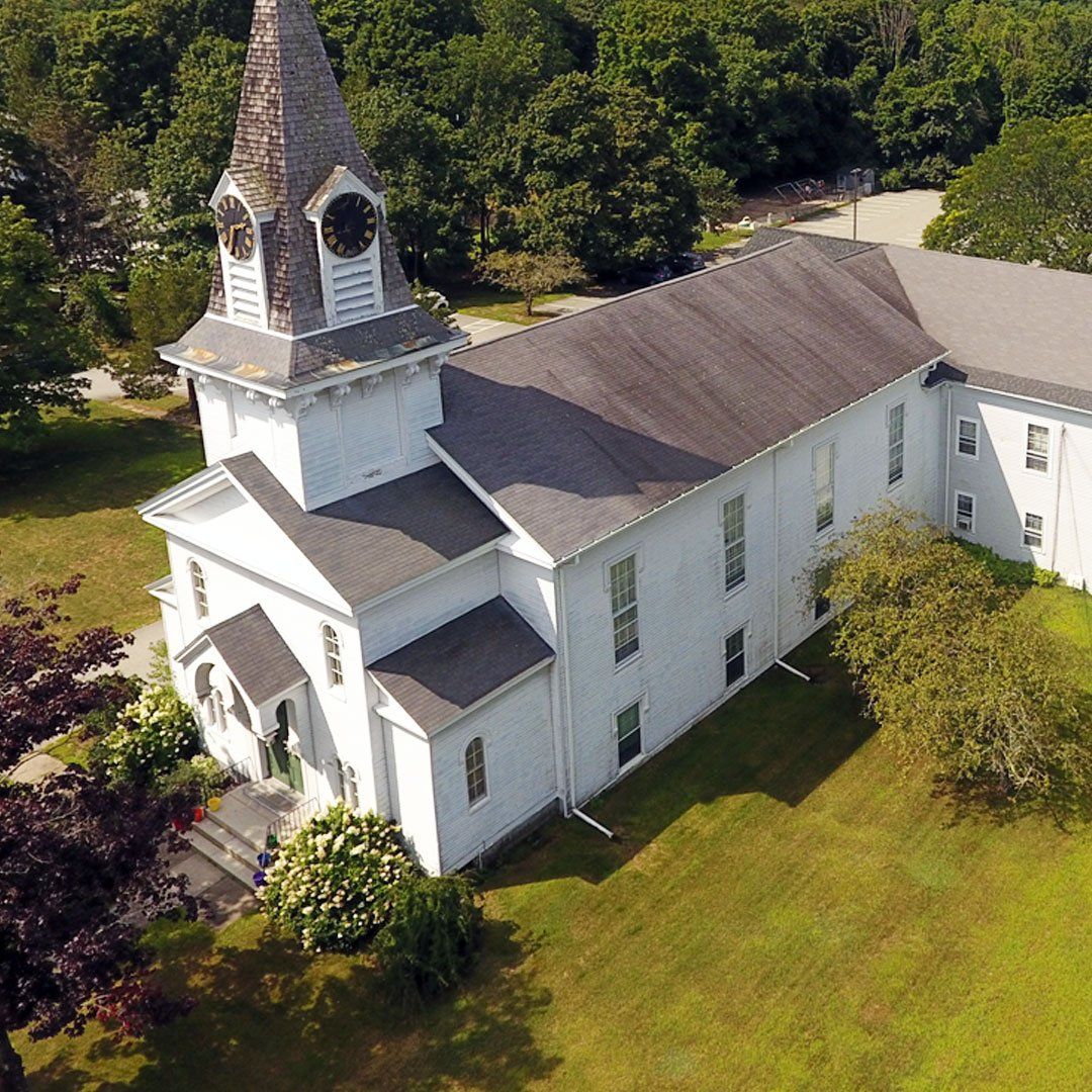 An aerial view of a white church with a clock tower