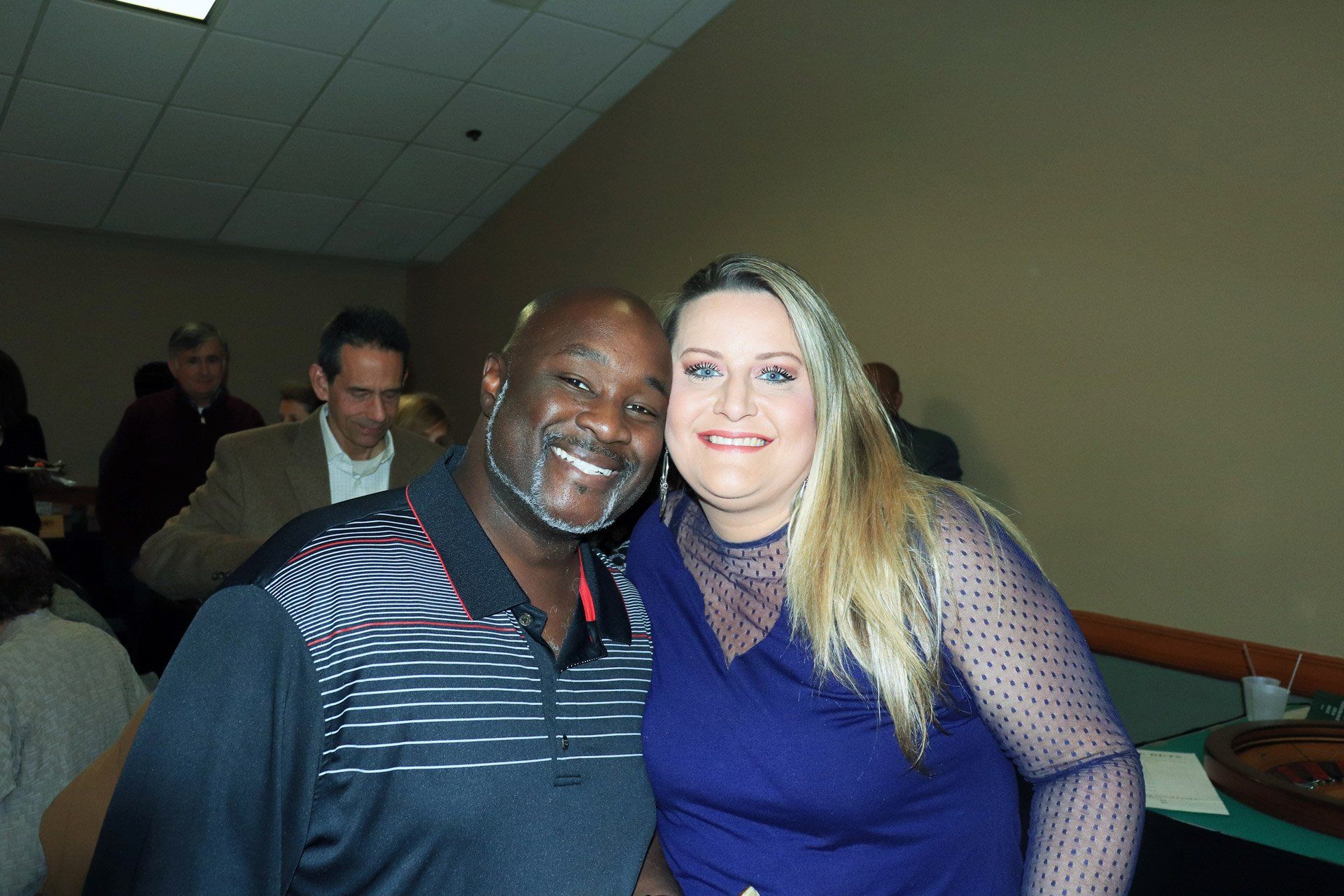 A man and a woman are posing for a picture in a room.