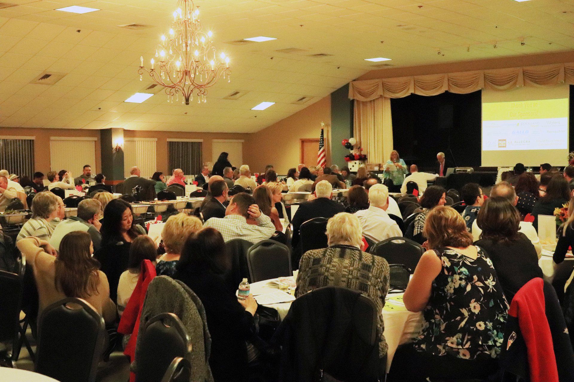 A large group of people are sitting at tables in a large room