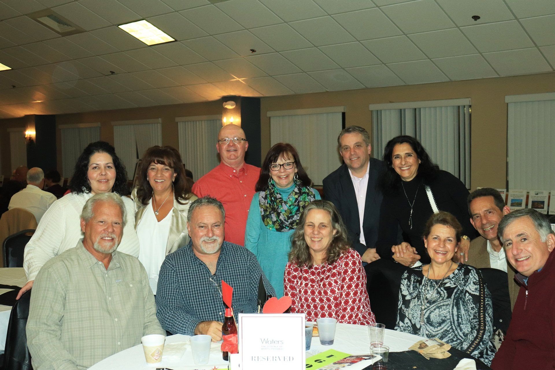 A group of people are posing for a picture at a table.