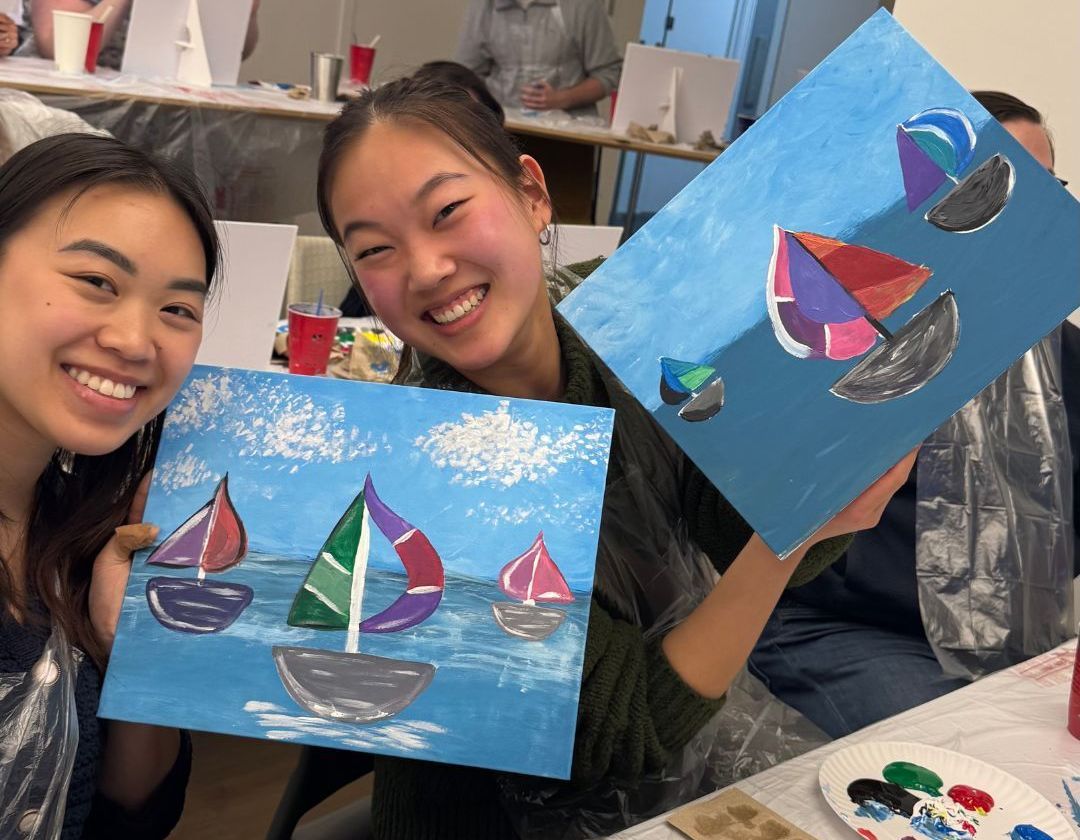 women holding  painted canvsesW