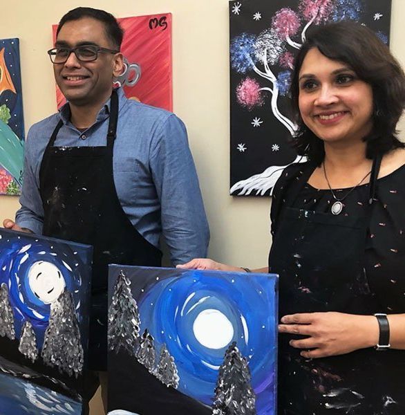 Couple painting a night scene together.