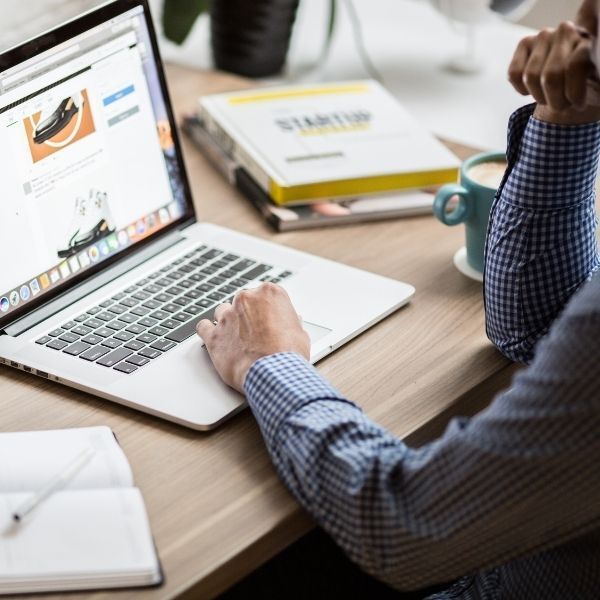 A man is sitting at a desk using a laptop computer