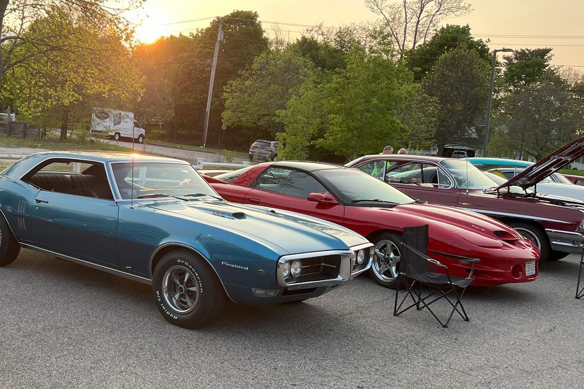 A blue car is parked next to a red car in a parking lot.