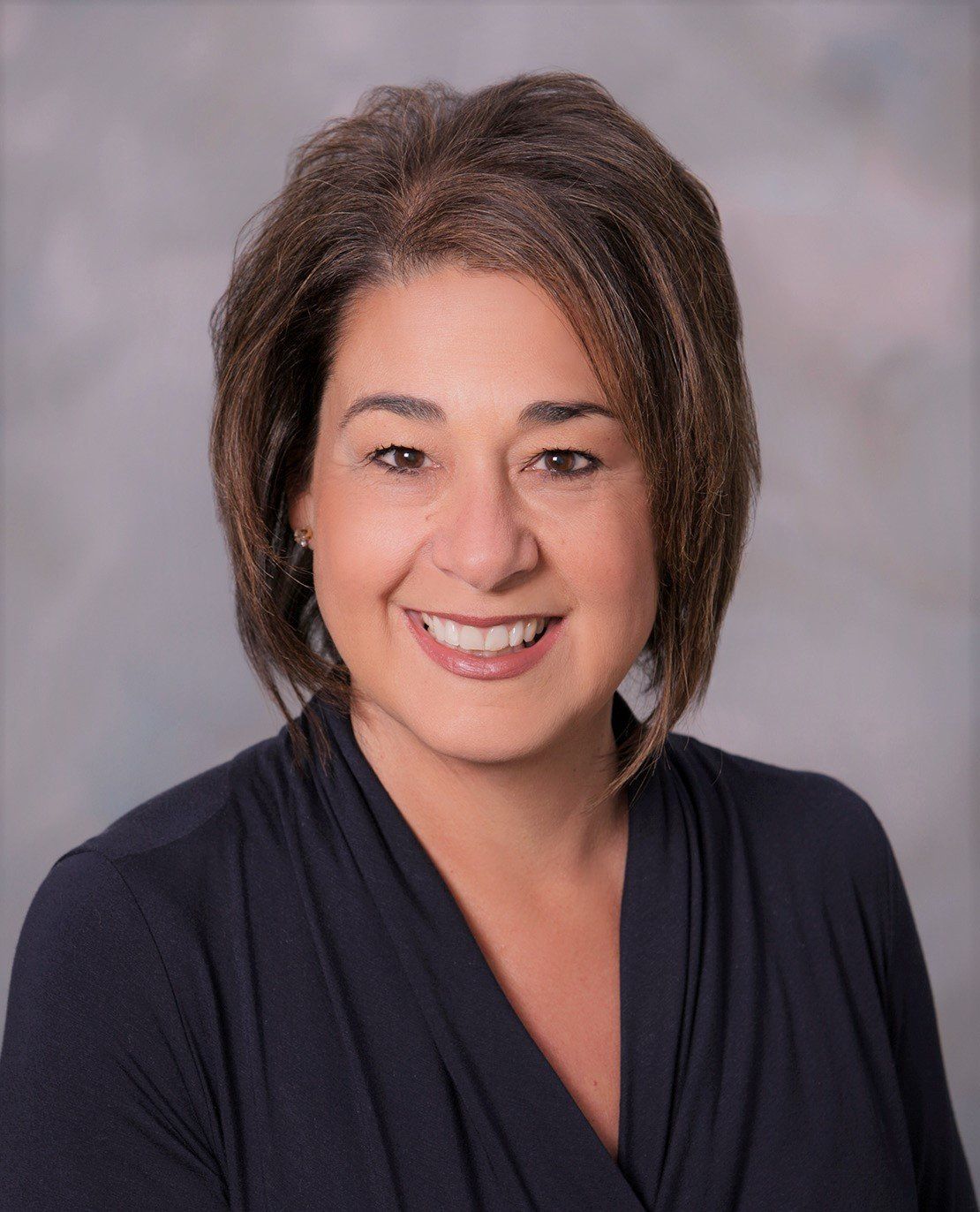 A woman in a black shirt is smiling for the camera.