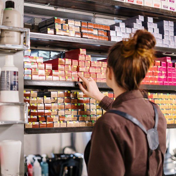 A woman is looking at boxes of hair color in a store