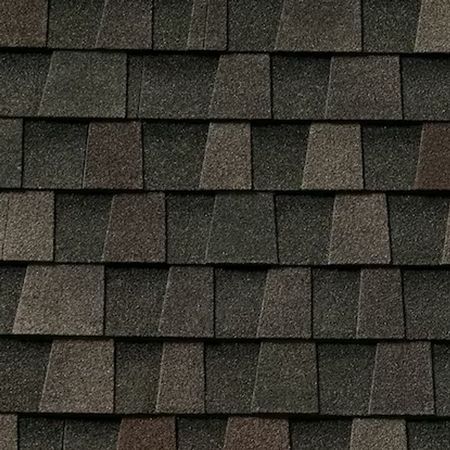 A pattern of overlapping dark gray and charcoal asphalt roof shingles with a varied, textured appearance.