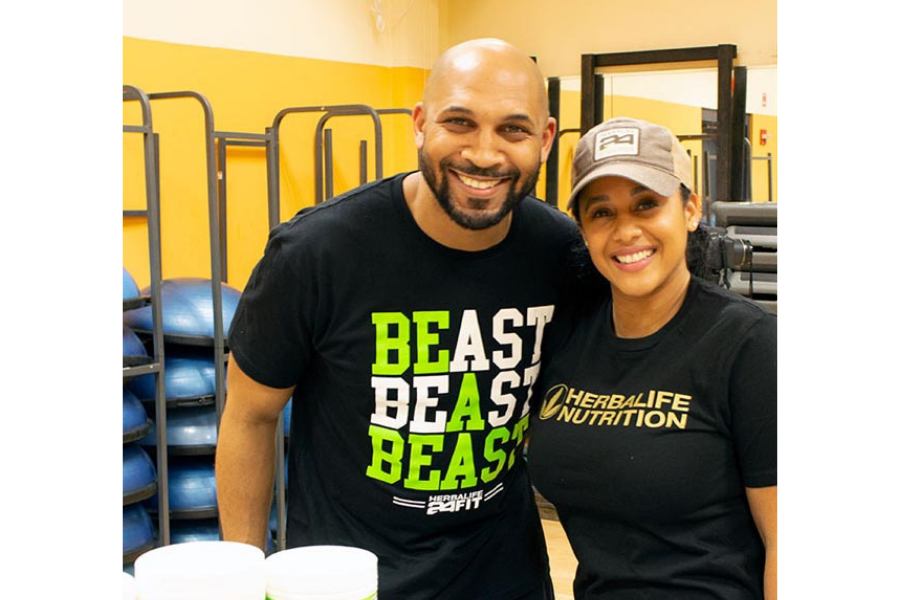 A man and a woman are posing for a picture in a gym.