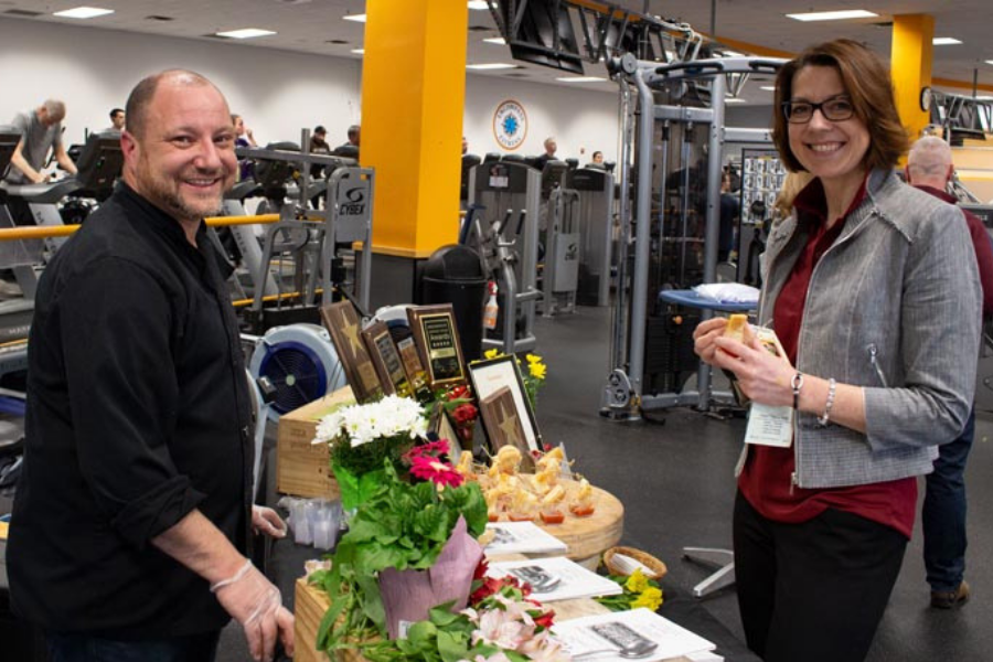 A man and a woman are standing next to each other in a gym.