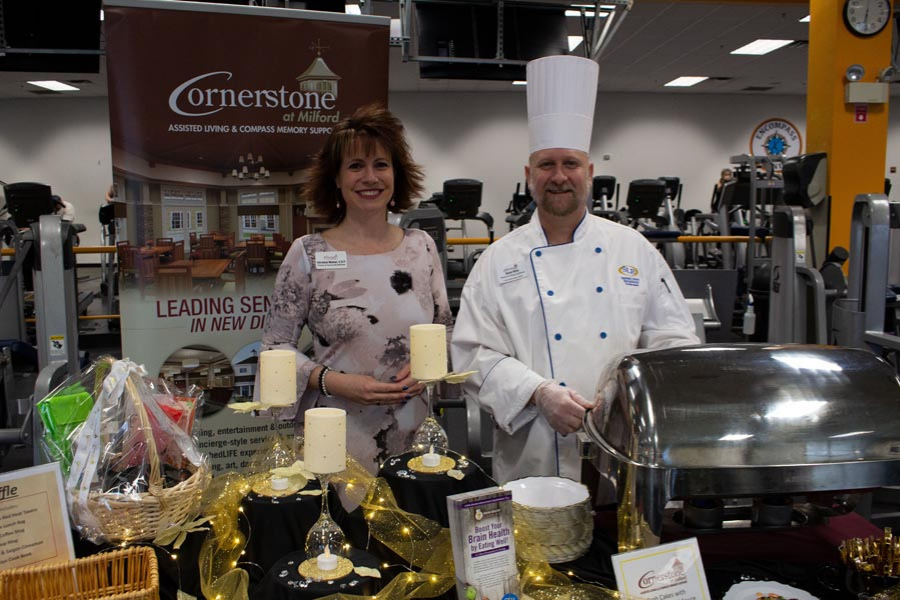 A man and a woman are standing in front of a buffet table.